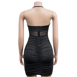 Close-up of black bodycon dress with back zipper, sheer mesh panels, and ruched texture