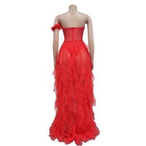 Rear view of a red strapless tulle dress with layered skirt and feather accessory