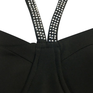 Détail de la bandoulière en V avec quatre rangées de strass argentés sur la robe noire