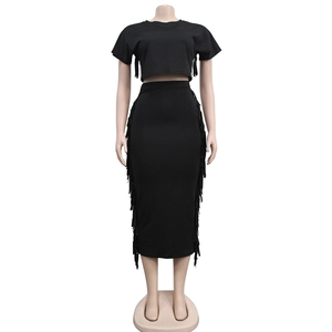 Détail d'un ensemble deux pièces noir avec franges sur le crop top et la jupe haute
