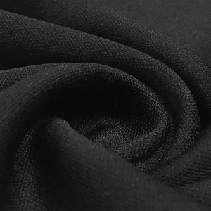 Macro texture of premium black knitted fabric with detailed mesh weaving and soft folds