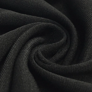 Détail du tissu en maille noire montrant la texture douce de cette robe de soirée