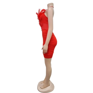 Detail of red bodycon mini dress featuring feather trim and horizontal pleats texture