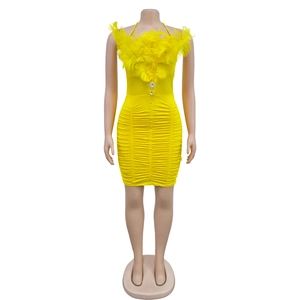 Close-up of yellow ruched mini dress featuring feather trim and rhinestone pendant detail