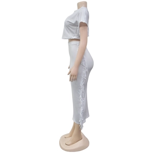 Détail de l'ensemble blanc deux pièces avec crop top et jupe longue à franges latérales
