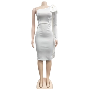 Detail of white one-shoulder dress showing oversized bow and elegant single long sleeve