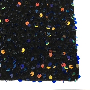 Macro d'un tissu en velours noir avec des paillettes multicolores à reflets métalliques