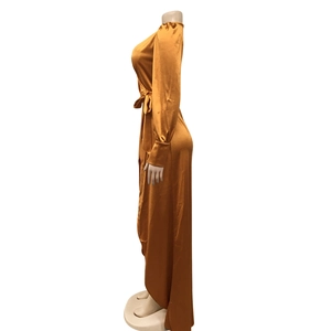 Détail d'une robe cache-cœur en satin doré avec manches longues élégantes et tissu fluide