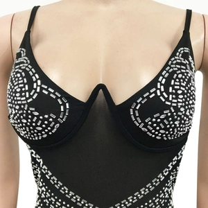 Detail eines schwarzen Mesh-Bodysuits mit silbernen Strasssteinen und V-Draht-Korsett