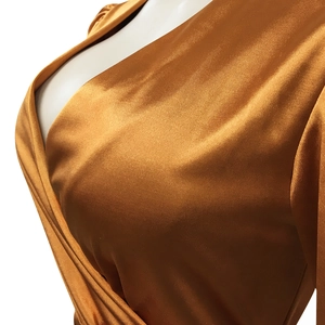 Détail du design cache-cœur en V avec texture satinée bronze métallique et plissée