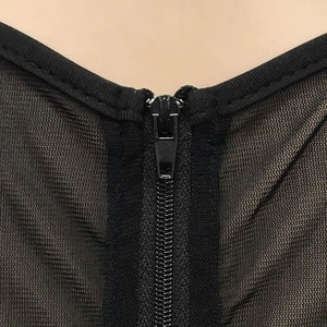 Dettaglio ravvicinato della cerniera e dello scollo in rete di un abito nero sexy