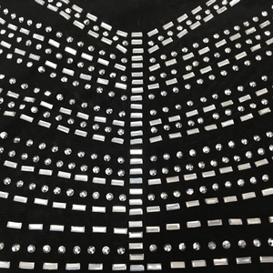 Detail funkelnder Strasssteine im V-Muster auf schwarzem, transparentem Netz-Kleid