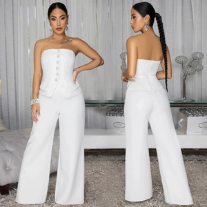 Detail of white tube top jumpsuit featuring sparkling diamond buttons and a peplum waist
