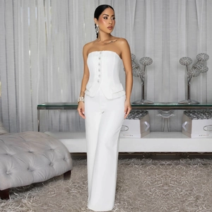 Detail of white tube top jumpsuit with sparkling buttons and elegant peplum waist
