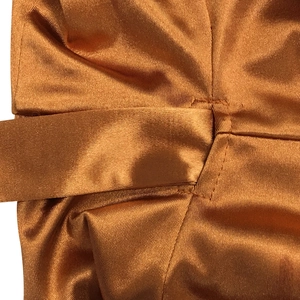 Vue macro du satin bronze montrant les détails de couture et le passant de ceinture
