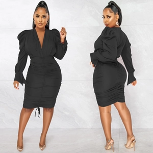 Détails de la robe noire avec col en V profond, manches bouffantes et ourlet à cordon
