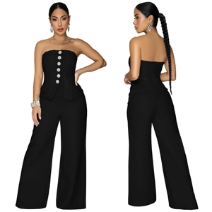 Detail of black tube top jumpsuit with silver buttons and elegant wide leg trousers