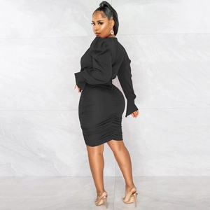 Détail d'une robe noire à col en V avec manches bouffantes et jupe à fronces élégantes