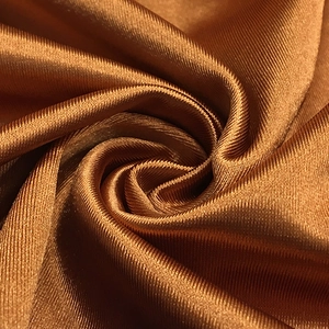 Gros plan sur un tissu côtelé bronze avec un éclat métallique et une texture en soie