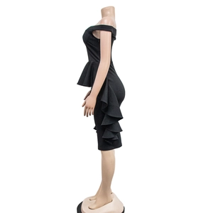 Detail of elegant black off-shoulder peplum dress with tiered ruffle fishtail hemline