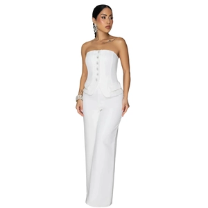 Detail of white strapless peplum top with jewelry buttons and wide leg trousers set