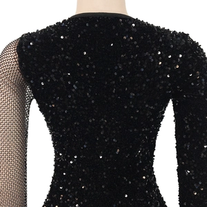 Detail von schwarzen Pailletten und Fischnetz-Ärmeln an einem sexy Damenkleid
