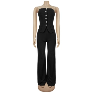 Detail of black strapless jumpsuit featuring rhinestone buttons and faux pocket flaps