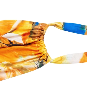 Detailed macro view of vibrant abstract print fabric with orange tones and stitching