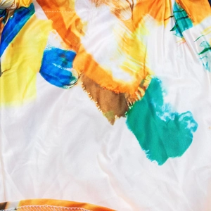 Macro shot of colorful abstract floral print fabric with silky texture and hem details