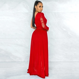 Detail of red one-shoulder jumpsuit featuring sheer mesh long sleeves and elegant pleats