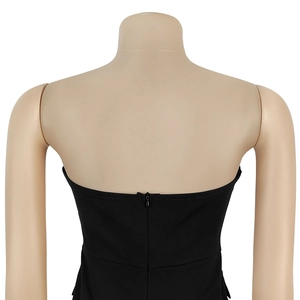 Detail view of the back zipper closure on a black strapless wide-leg jumpsuit