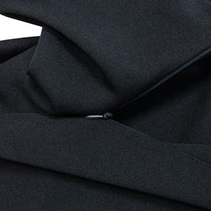 Detail of hidden zipper closure on black sleeveless dress with fine textured fabric