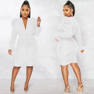 Détails de la robe blanche froncée à col en V avec manches bouffantes et coupe ajustée