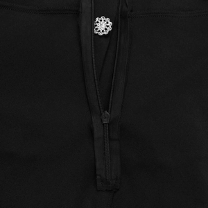 Close-up of a black jumpsuit featuring a central zipper with a flower rhinestone buckle