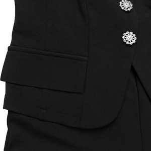 Close-up of black fabric with sparkling crystal flower buttons and pocket detail