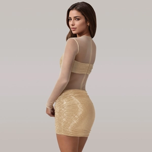 Nahaufnahme der goldenen Pailletten auf einem figurbetonten Kleid mit Netzärmeln