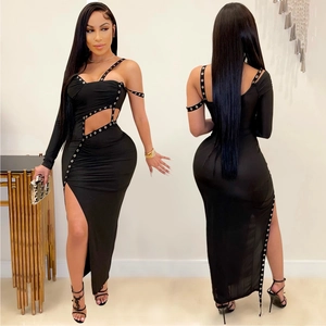 Détail d'une robe noire moulante avec découpes, œillets métalliques et fente haute