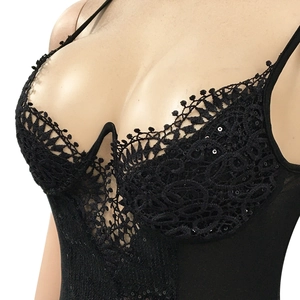 Détail d'un body en dentelle noire avec paillettes scintillantes et bonnets à armatures