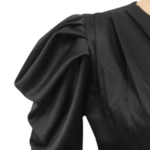Détail de manches bouffantes noires élégantes avec texture plissée sur la robe en V