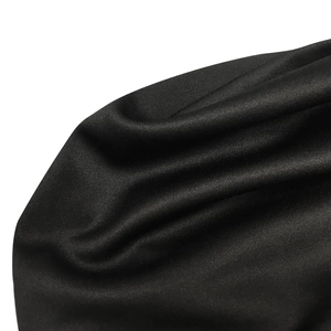 Détail rapproché de la texture du tissu en maille noire avec un motif fin et un drapé élégant