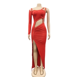Détail de robe rouge évidée avec œillets métalliques et découpe asymétrique à la taille
