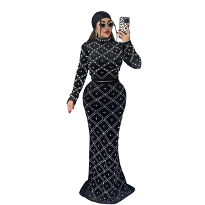 Close-up of elegant black modest two-piece set with white diamond patterns and pearls