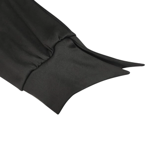 Détail du poignet noir à manches longues avec texture plissée et design plié en V