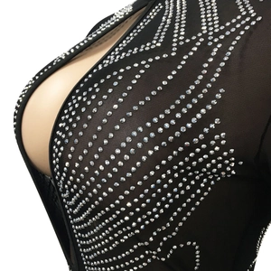 Dettaglio di un abito in mesh nero trasparente con strass argentati e profondo scollo a V