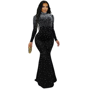 Détails d'une robe noire moulante à col montant ornée de perles blanches et strass
