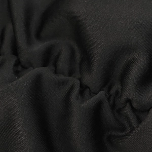 Gros plan sur la texture du tricot noir montrant des détails plissés et un drapé doux