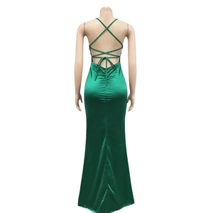 Detail of the emerald green satin dress featuring cross back straps and pleated texture
