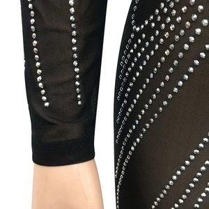 Dettaglio di abito in rete nera trasparente con eleganti strass argentati verticali