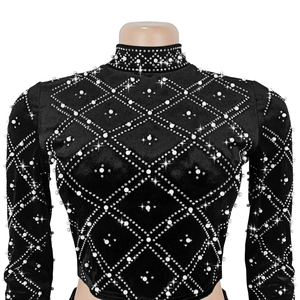 Detail showing white pearls and sparkling rhinestones on the black velvet top