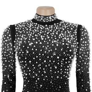 Vue détaillée de la robe à col montant avec perles blanches et ornements en strass brillants